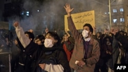 Protesters chant slogans and hold a placard reading in Farsi "Your mistake was unintentional, your lie was intentional," during an anti-govenrnment rally outside Amir Kabir University, in Tehran, Iran, Jan. 11, 2020.