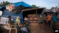FILE - Rohingya Muslim rest in front of a grocery shop at a camp for refugees in Hyderabad, India, Monday, Sept. 18, 2017.