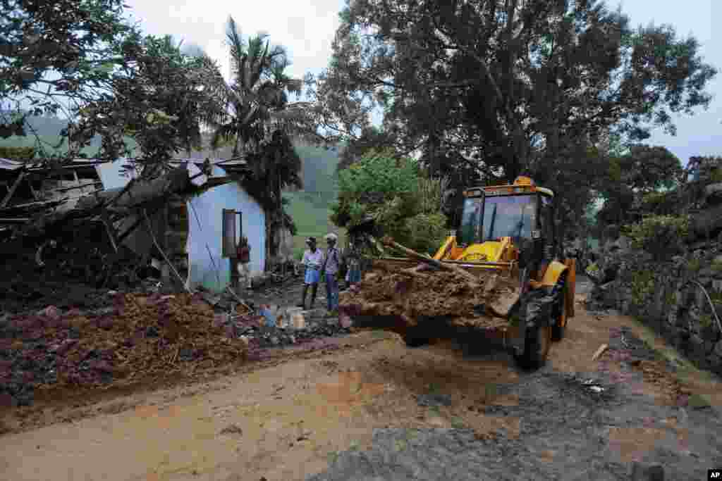 An earthmover clears debris caused by a mudslide at the Koslanda tea plantation in the Badulla district, Sri Lanka, Oct. 29, 2014. 