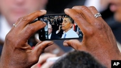 President Barack Obama is seen on a phone camera as he greets the crowd after speaking in Phoenix, Arizona, Aug. 6, 2013.