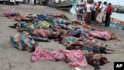 FILE - Bodies of Somali migrants, killed in attack by a helicopter while traveling in a boat off the coast of Yemen, lie on the ground at Hodeida city, Yemen, Mar. 17, 2017. 