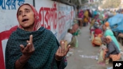 FILE - Anwara, 55, a Bangladeshi daily wage laborer who earns less than $4 per day, laments the lack of work due to the political unrest as she awaits work by a roadside during the second day of a 72 hours long strike called by the opposition Bangladesh National Party.