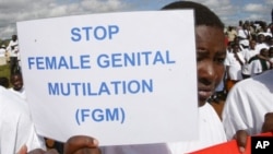 FILE - Masai girl holds protest sign during anti-Female Genital Mutilation run in Kilgoris, Kenya. The practice is found in Singapore, and according to the U.N. in 30 other countries as well, almost all in Africa. Indonesia is the only Asian country the U.N. cites.