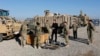 Britain's Prime Minister David Cameron chats with soldiers in front of Mastiff armored vehicles at Camp Bastion, outside Lashkar Gah, in Helmand Province, Afghanistan, Dec. 20, 2012.