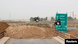 Islamic State flags flutter on the Mullah Abdullah bridge in southern Kirkuk, Iraq, Sept. 29, 2014. 
