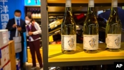 资料照片: 2020年11月5日上海中国国际进口博览会上工作人员在澳大利亚葡萄酒展区与参观者交谈