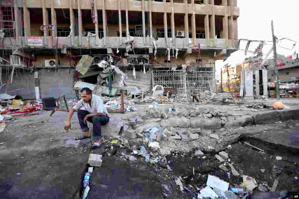 An Iraqi man inspects the site of a car bomb attack in central Baghdad&#39;s busy commercial Karradah neighborhood, Aug. 13, 2014.