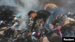 People salvage goods from an aid convoy that was damaged during an airstrike in the rebel held area of al-Sakhour district of Aleppo, Syria, June 4, 2016.