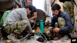 Citizen journalism image provided by Aleppo Media Center AMC which has been authenticated based on its contents and other AP reporting, shows members of the free Syrian Army preparing their weapons, April 25, 2013.