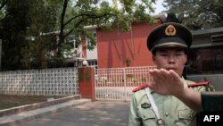 A paramilitary police officer outside the Belgium embassy in Beijing, June 19, 2019. A Belgian diplomat was to travel to China's Xinjiang region to confirm the whereabouts of a Uighur family escorted from the embassy in Beijing by police last month.