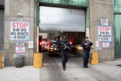 Armed corrections officers clear the sidewalk for an ambulance escorting Harvey Weinstein from a Manhattan courthouse in New York. Feb. 24, 2020.