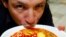 FILE - Chef Bobby Chinn sips from a bowl of Laksa, a dish popular in Singapore hawker centres, while posing for a photo in Singapore. 