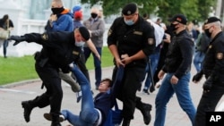 Police officers detain a protester during a rally against the removal of opposition candidates from the presidential elections in Minsk, Belarus, July 14, 2020.