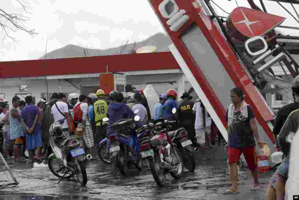 Typhoon survivors pump out fuel from a damaged filling station, Nov. 14, 2013, in Tacloban city, Philippines.&nbsp;