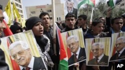 Palestinians shout slogans to support Palestinian President Mahmoud Abbas ahead of his meeting with U.S. President Barack Obama Monday, Tubas, West Bank, March 16, 2014.