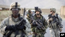 French army Captain Jeremy Reynaud (C) walks with U.S. soldiers after a joint patrol with Afghan troops in a village in Wardak province, Afghanistan. (file photo)