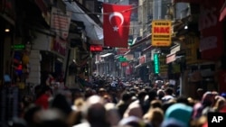 FILE - In this Friday, March 24, 2017 file photo, people fill an open market in the historic Sultanahmet district of Istanbul. (AP Photo/Lefteris Pitarakis, file)