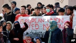 FILE - Migrants shout slogans during a protest over dire living conditions in Mytilene port, on the northeastern Aegean island of Lesbos, Greece, on Feb. 4, 2020. 