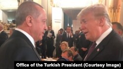 Presiden Turki Recep Tayyip Erdogan berbincang dengan Presiden AS Donald Trump pada acara makan malam yang diadakan Presiden Macron di Paris, Perancis, 10 November 2018 lalu (foto: dok). 