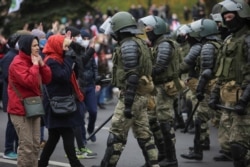 Belarusian law enforcement officers block opposition supporters during their rally to reject the presidential election results in Minsk, Belarus, Nov. 1, 2020.