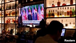 A television screen at the Baro bar broadcasts the Singapore summit meeting between U.S. President Donald Trump and North Korean leader Kim Jong Un, as customers sit at the bar in the Korea Town section of Manhattan, New York, U.S., June 11, 2018. 