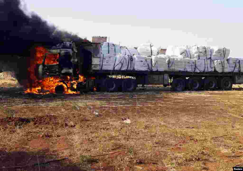 A truck catches flames after it was hit by rockets fired by a Syrian Air Force fighter plane during an air strike in the village of Tel Rafat, some 37 km (23 miles) north of Aleppo, August 9, 2012. 