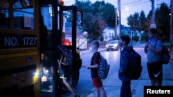Eliot Miller y otros estudiantes caminan hacia el autobús escolar el primer día de clases en Louisville, Kentucky, EE. UU. 