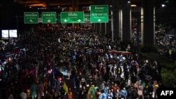 Protesters walk along a road during an anti-government rally at the Lat Phrao intersection in Bangkok, Thailand, Oct. 17, 2020, as they continue to defy an emergency decree banning mass gatherings.