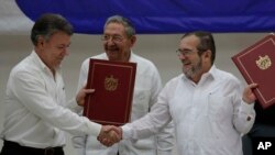 Shugaban Colombia Manuel Santos daga hagu, madugun 'yan tawaye Timoleon Jimenez da dama sai kuma shugaban kasar Cuba Raul Castro a tsakiya