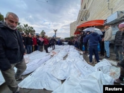 Mourners react next to the bodies of Palestinians killed in Israeli strikes, amid the ongoing conflict between Israel and Hamas, at a hospital in the central Gaza Strip, Dec. 25, 2023.