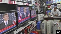 A Palestinian watches the speech of US President Barack Obama on television at a store in Gaza City, May 19, 2011