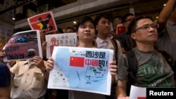 Anti-Vietnam protesters hold posters with slogans and a picture showing a map of the South China Sea, including the Paracel Islands, during a rally in Hong Kong defending China's territorial claims, May 19, 2014.