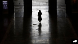 Un solitario pasajero sale de la estación de trenes de Milán, Italia, el lunes 9 de marzo de 2020. El gobierno italiano amplió a todo el país la restricción de viajes que había impuesto solo al norte de la nación.