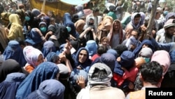 FILE - Internally displaced families from northern provinces take shelter in a public park in Kabul, Afghanistan, Aug. 10, 2021.