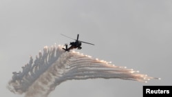 FILE - AH-64 Apache helicopter fires flares during Han Kuang military drill simulating the China's People's Liberation Army invading the island, at Ching Chuan Kang Air Base, in Taichung, Taiwan, June 7, 2018.