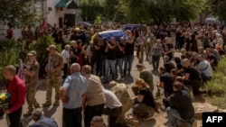 Men carry coffins during the funeral of six Ukrainian servicemen, who were killed since Ukraine launched its offensive at the Russian border region of Kursk, in Sumy, northeastern Ukraine, Aug. 15, 2024.