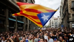 Warga dengan membawa "estelada" atau bendera Catalonia, berkumpul dan berunjuk rasa di depan kantor polisi di Barcelona, Spanyol, 3 Oktober 2017.