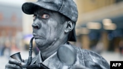 The detective Sherlock Holmes is good at finding clues! Here, a performer poses as a human statue of the famous detective at King's Cross Square rail station in London, 2013. 