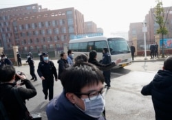 FILE - Journalists and security personnel gather near the entrance of the Wuhan Institute of Virology after a visit by the World Health Organization team in Wuhan in China's Hubei province, Feb. 3, 2021. (AP Photo/Ng Han Guan)