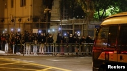 Supporters of pro-democracy activists hold flashlights as a prison van carrying some of the 47 pro-democracy activists charged under the national security law arrives at Lai Chi Kok Reception Centre, in Hong Kong, March 4, 2021. 