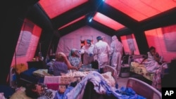 FILE: Medical staff treat a coronavirus patient at a tent hospital erected for COVID-19 patients in Kakhovka, Ukraine, Nov. 7, 2021.