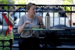 A woman enjoys lunch at the Mount Vernon Place Square in the Mount Vernon section of Baltimore, July 29, 2019.