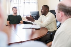 Commandant Nabugere Michael Joel, an official at Bidi Bidi, takes questions from a recent U.S. delegation that included Senator Chris Coons and Senator Chris Van Hollen. Bidi Bidi Camp, August 13, 2019. (I. Godfrey/CARE)