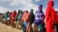 Women who fled drought queue to receive food distributed by local volunteers at a camp for displaced persons in the Daynile neighborhood on the outskirts of Mogadishu, in Somalia, May 18, 2019. 