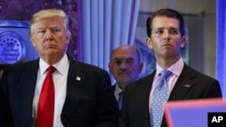 FILE - In this Jan. 11, 2017, shows President-elect Donald Trump, left, his chief financial officer Allen Weisselberg, center, and his son Donald Trump Jr., right, attend a news conference in the lobby of Trump Tower in New York. Manhattan prosecutors hav