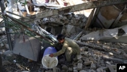FILE - An Afghan man searches for the remains of his belongings at his shop following a Taliban attack in Kabul, Afghanistan, July 2, 2019. 