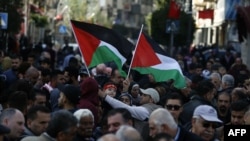 Warga Palestina mengibarkan bendera nasional dan menyerikan persatuan seluruh wilayah Palestina dan penghentian permusuhan antara Fatah dan Hamas, di Ramallah, Tepi Barat (foto: dok). 