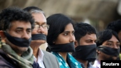 FILE - Activists of the leftist alliance cover their mouths with black cloths as they join in a rally to demand a new election under caretaker government, in Dhaka, Bangladesh, Jan. 3, 2019.