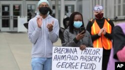 A protester holds a sign with the names of people who have died while in police custody or during police actions, or who were victims of alleged racially motivated killings, June 5, 2020, in Tacoma, Wash.