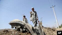 Afghan boys collects the remains of a suicide attacker's vehicle in Kabul, Afghanistan, Wednesday, July 24, 2019. 
